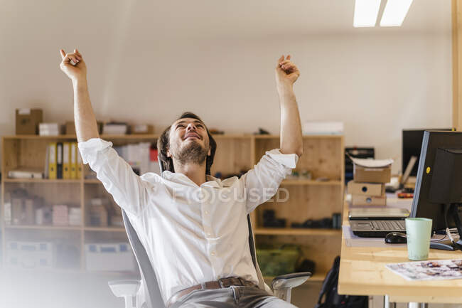 Businessman cheering at desk in office — Stock Photo