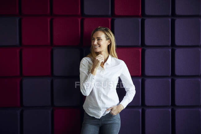 Porträt einer lächelnden Frau an einer lila Wand — Stockfoto