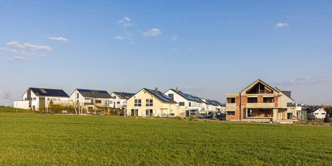 Germany, Baden-Wurttemberg, Waiblingen, Grassy field in front of modern energy efficient suburb houses — Stock Photo