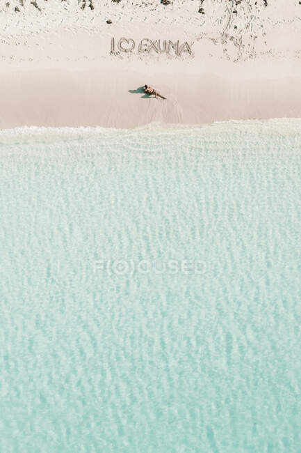 Жінка, яка купається під текстом Я люблю Ексуму, Багами, Карибське море. — стокове фото