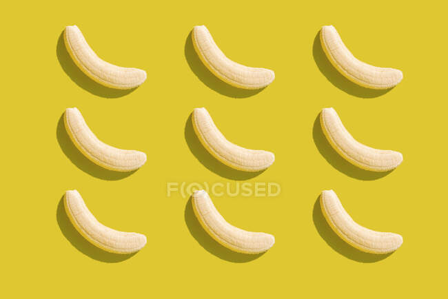 Ilustración 3D de plátanos pelados sobre fondo amarillo - foto de stock