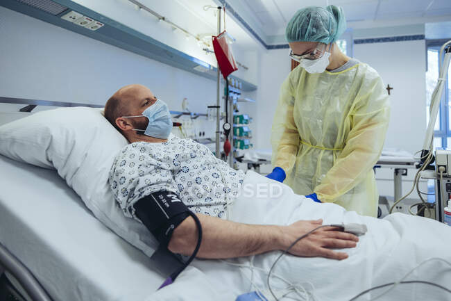 Doctor caring for patient in emergency care unit of a hospital taking blood sample — Stock Photo