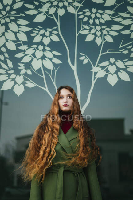 Retrato de ruiva jovem com cabelo soprando olhando para cima — Fotografia de Stock