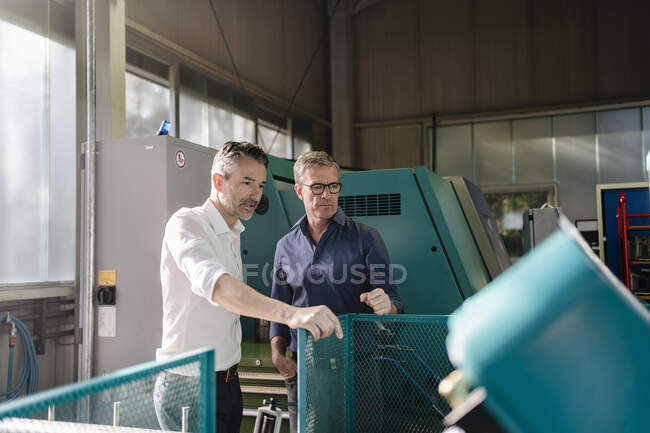 Les hommes d'affaires dans l'usine, avoir une réunion, discuter des solutions — Photo de stock