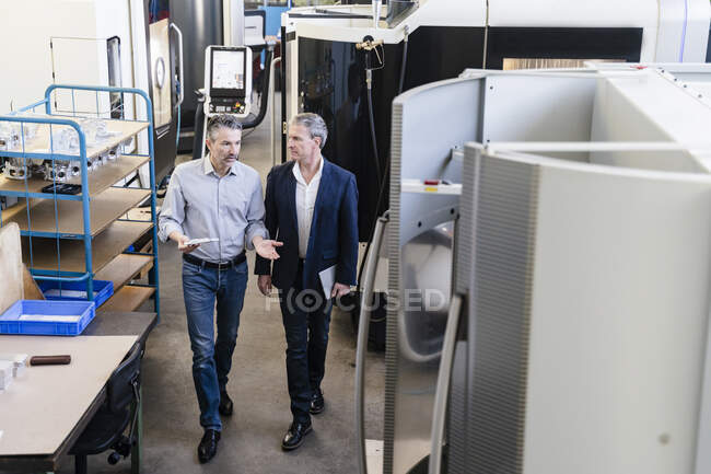 Empresários na fábrica tendo uma reunião na sala de produção — Fotografia de Stock