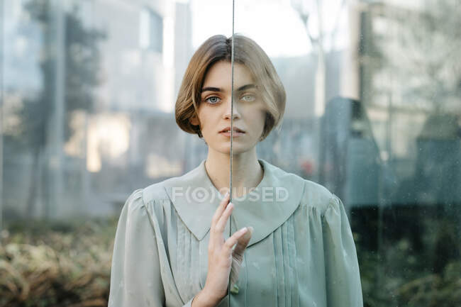 Retrato de mulher com metade do rosto atrás de um copo — Fotografia de Stock