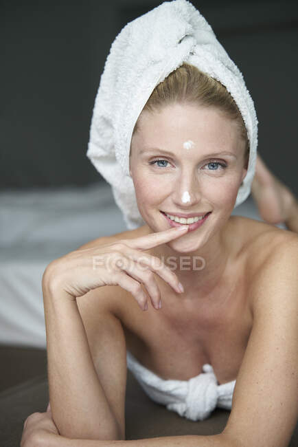 Девушка в полотенце делает селфи перед зеркалом в ванной