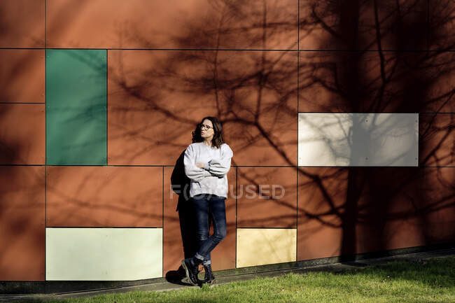 Femme penchée sur un mur multicolore — Photo de stock