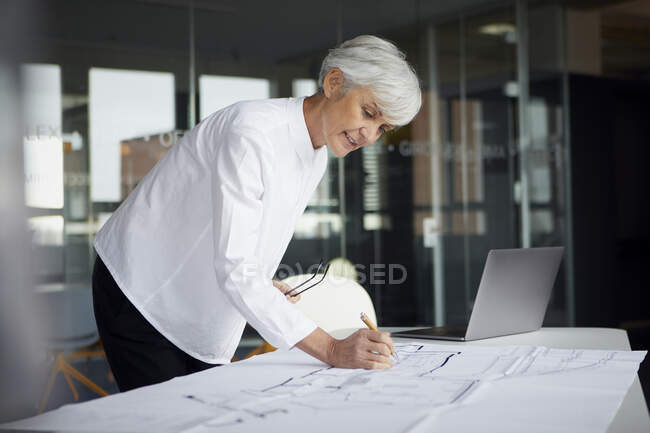 Ritratto di architetto che lavora al piano di costruzione in ufficio — Foto stock