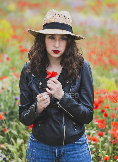 Портрет молодої жінки з червоними губами стоїть на макове поле. — стокове фото