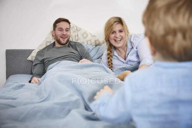 Родина під час бійки подушок на ліжку. — стокове фото