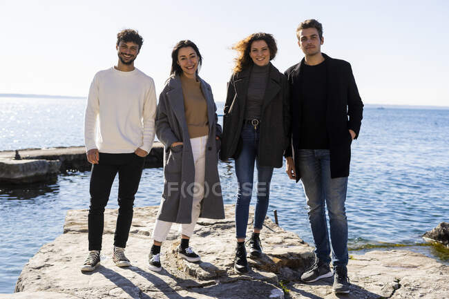 Portrait of four friends standing at Lake Garda, Italy — Stock Photo