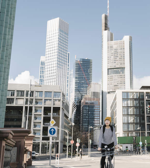Woman riding bicycle in the city, Frankfurt, Germany — Stock Photo
