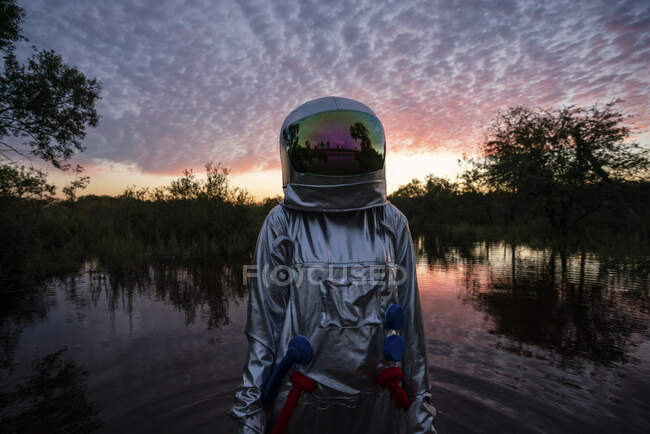 Ritratto di donna spaziale in piedi in acqua al tramonto — Foto stock