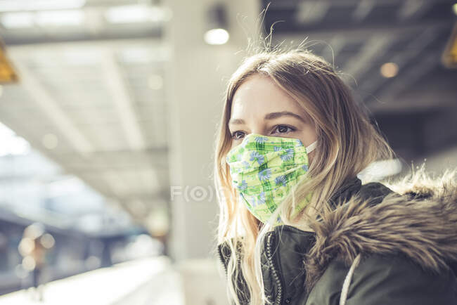 Portrait de jeune femme portant un masque au quai de la gare — Photo de stock