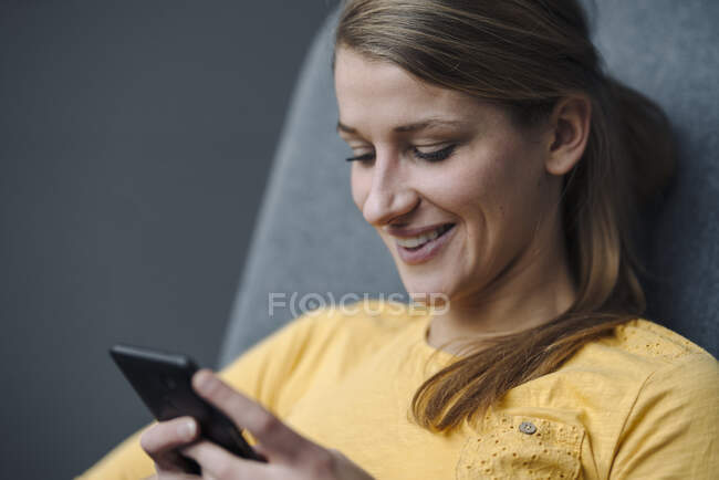 Portrait of smiling young woman using smartphone — Stock Photo
