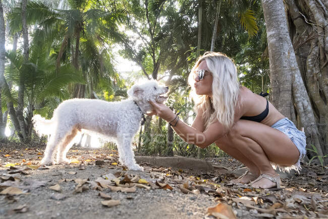 Hermosa mujer jugando con su perro en la playa, Costa Rica - foto de stock
