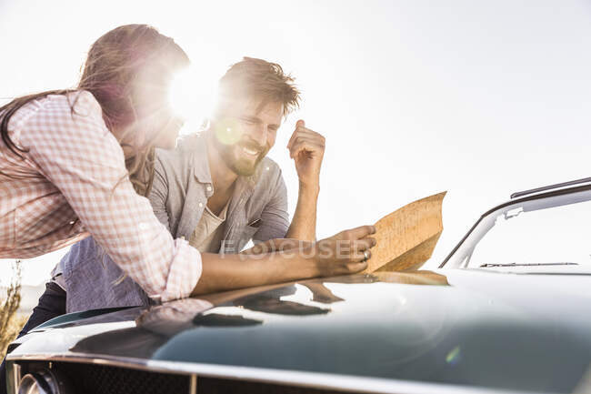 Couple sur une route lecture de carte — Photo de stock