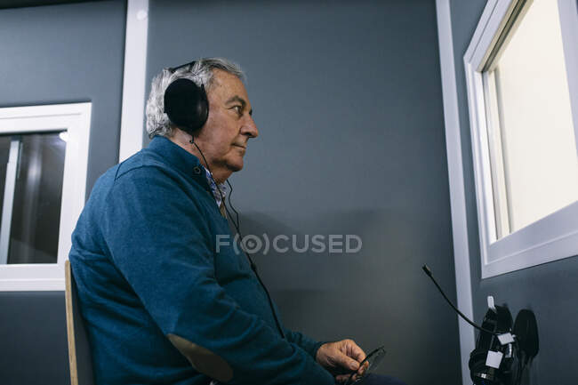 Paciente com fones de ouvido durante um teste auditivo — Fotografia de Stock