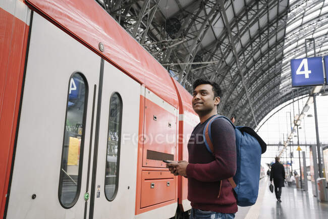 Uomo con smartphone alla stazione ferroviaria — Foto stock