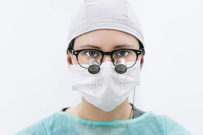 Retrato de dentista con lupa y máscara - foto de stock
