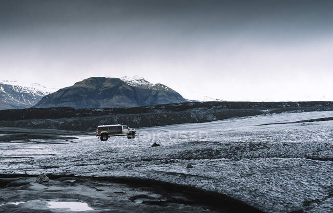 Mini van en medio de un paisaje dramático en Jokulsarlon, Islandia - foto de stock