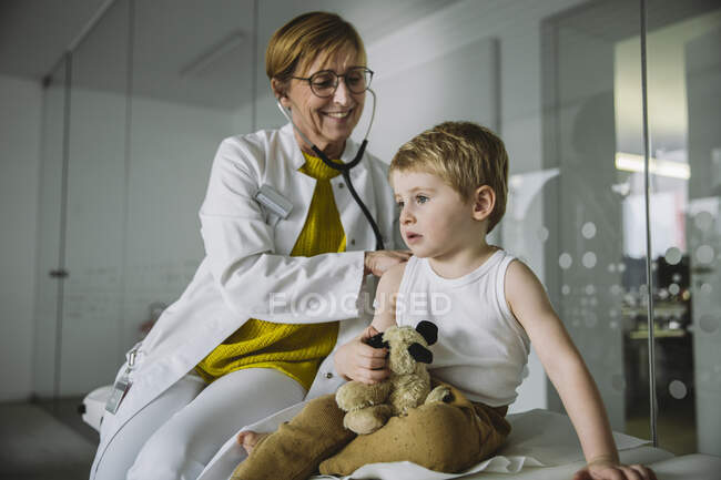 Doctor examining toddler boy with a stethoscope — Stock Photo