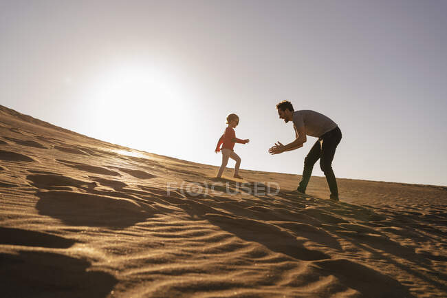 Vater und Tochter spielen in der Sanddüne bei Sonnenuntergang, Gran Canaria, Spanien — Stockfoto
