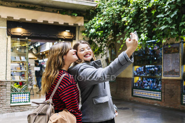 Dos jóvenes felices tomando una selfie en la ciudad - foto de stock
