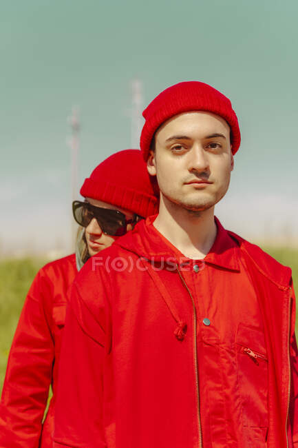 Portrait de jeune homme et sa petite amie portant des vêtements rouges à l'extérieur — Photo de stock