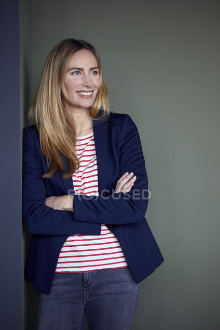 Portrait of smiling businesswoman leaning against a wall — Stock Photo