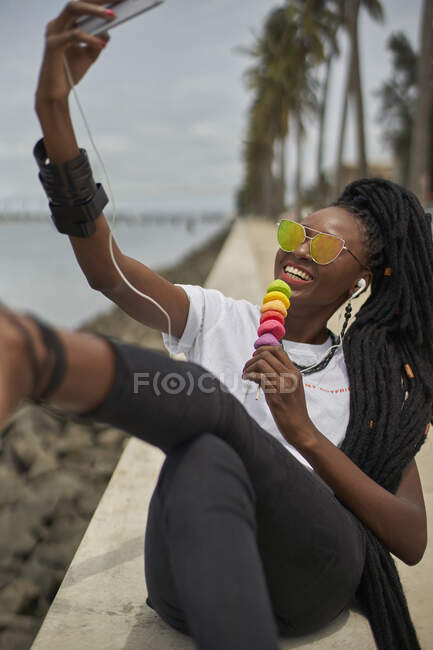 Ritratto di donna ridente con dreadlocks scattare selfie con smartphone, Maputo, Mozambico — Foto stock