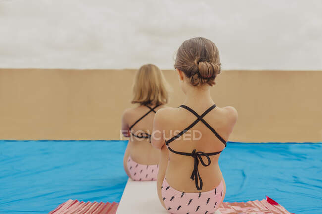 Back view of two girls playing swimmingpool on roof terrace — Stock Photo