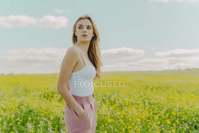 Девушка, стоящая на цветочном лугу весной — стоковое фото