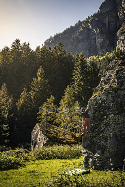 Man climbing up rock on mountain pasture in Zillertal; Ginzling, Tirol, Austria — Stock Photo