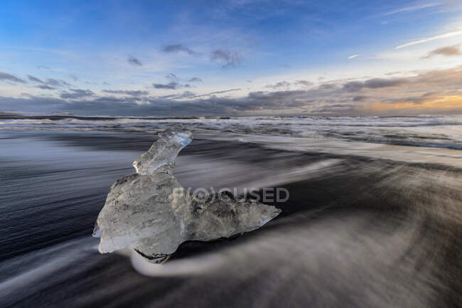 Islanda, pezzo di ghiaccio sdraiato sulla riva del Jokulsarlon al crepuscolo — Foto stock