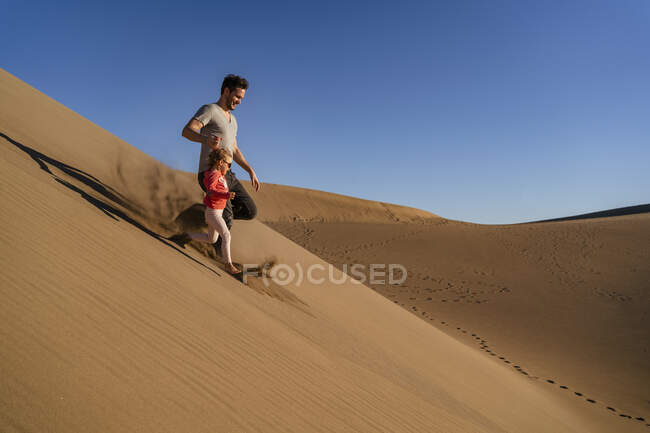 Father and daughter running down sand dune, Gran Canaria, Spain — Stock Photo