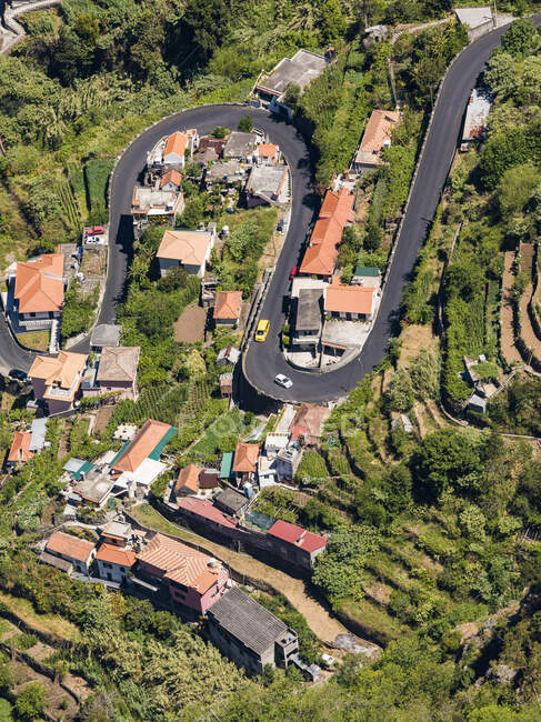 Portugal, Madeira, Curral das Freiras, High angle view of winding road stretching across mountain village — Stock Photo