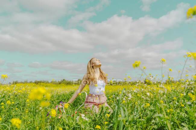 Молода жінка на квітковому лузі навесні — стокове фото