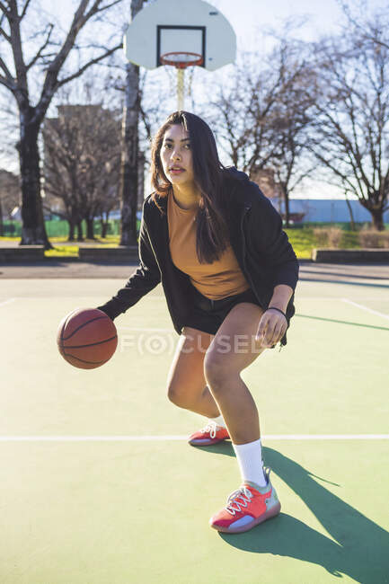 Portrait of female basketball player in action on court — women power, sky  - Stock Photo | #472824610