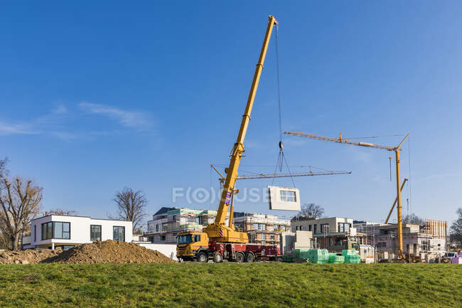 Germany, Baden-Wurttemberg, Ludwigsburg, Mobile crane at construction site in modern suburb — Stock Photo
