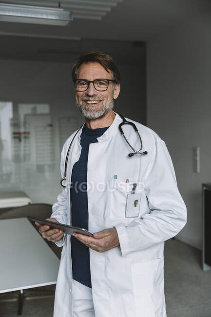 Портрет улыбающегося доктора с табличкой — стоковое фото