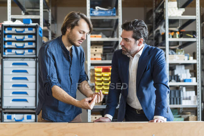 Бізнесмен і працівник говорять на фабриці — стокове фото