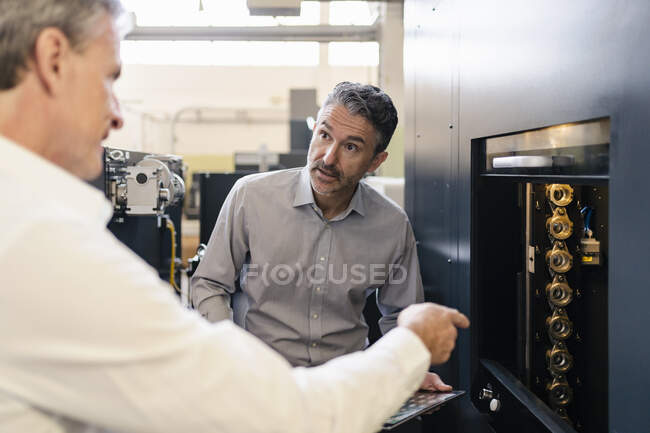 Businessmen in factory, having a meeting, discussing solutions — Stock Photo