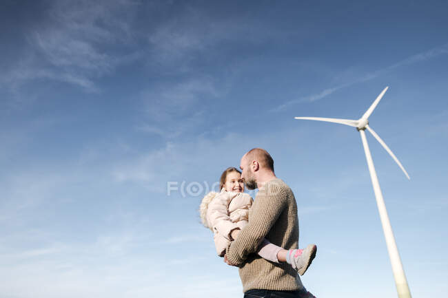Uomo maturo con la sua piccola figlia contro il cielo — Foto stock