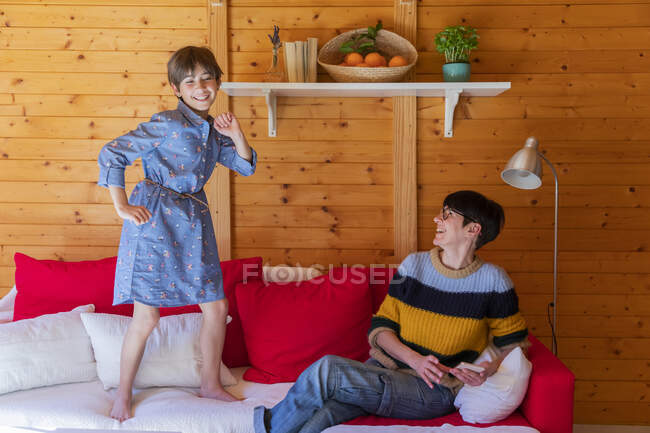 Happy mother and daughter on couch in a wooden cabin — Stock Photo