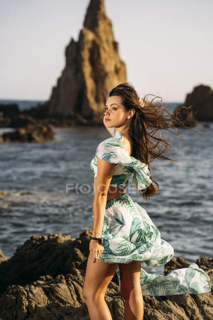 Jeune fille portant longyi et haut à la plage rocheuse — Photo de stock