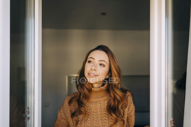Retrato de una joven en la ventana - foto de stock