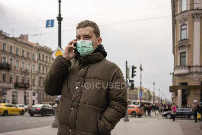 Молодой человек в маске, добирающийся на работу в город, Санкт-Петербург, Россия — стоковое фото