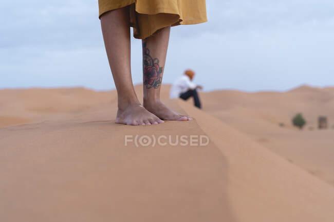 Pieds d'une femme debout sur une dune de sable dans le désert du Sahara, Merzouga, Maroc — Photo de stock